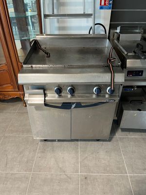 a large stainless steel grill in the middle of a kitchen