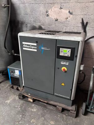 un petit compresseur d'air posé sur une palette dans un garage