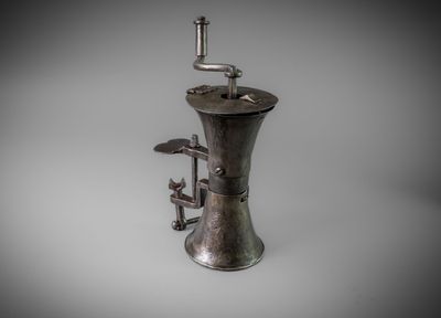 a silver coffee grinder sitting on a white surface