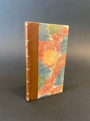 an old book with a brown cover sitting on top of a table
