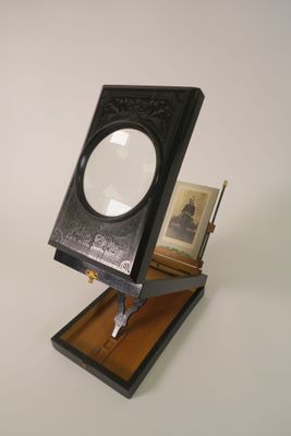 une petite boîte noire sur laquelle est posée une loupe