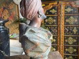 a statue of a woman with a turban on top of a wooden table