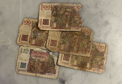 several pieces of paper money sitting on top of a marble counter