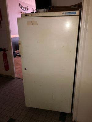 a white refrigerator sitting in a kitchen next to a door