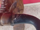 a close up of a wooden animal head on a handle