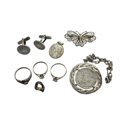 an assortment of silver jewelry on a white background with a white background
