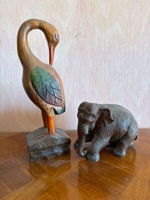 statue of a bird and an elephant on a wooden table