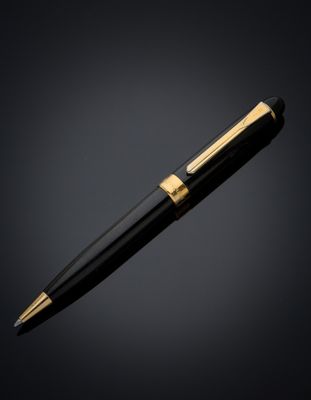 a black and gold ballpoint pen on a black background