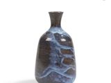 a blue vase that is sitting on a white surface