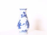 un vase bleu et blanc posé sur une table blanche