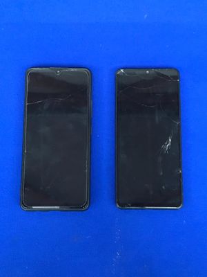 deux téléphones portables noirs posés l'un à côté de l'autre sur une surface bleue