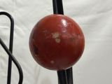 a red ball sitting on top of a metal stand