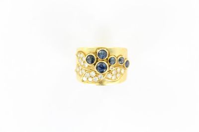 gros plan d'une bague en or avec saphirs et diamants