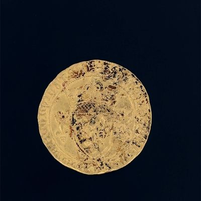 une vieille pièce d'or posée sur une surface noire, avec un fond noir