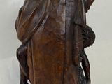 statue of a man sitting on a rock with a bird in his hand
