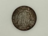 an old silver coin with a picture of a woman and a man on it