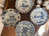 several blue and white plates and bowls on a wooden table