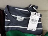 a pile of clothing on a couch with a price tag on it