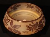 a white bowl with brown flowers on it on a black surface