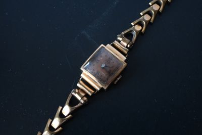 a close up of a wrist watch on a black surface