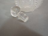 a small glass bottle with a glass stopper on a table