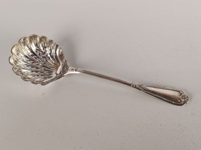 un gros plan d'une cuillère en argent ornée d'une feuille