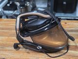 a black and silver steam iron on a wooden table