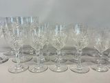 twelve crystal wine glasses lined up on a table