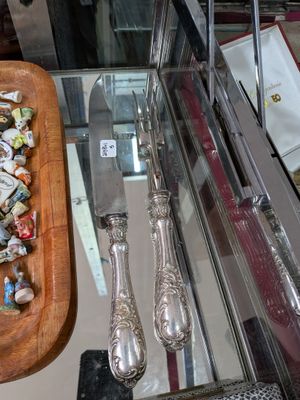 un plateau en bois sur lequel sont posés des couverts, à côté d'un couteau et d'une fourchette
