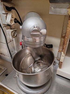a large metal bowl with a whisk inside of it