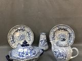 trois pièces de poterie bleue et blanche sont disposées les unes à côté des autres