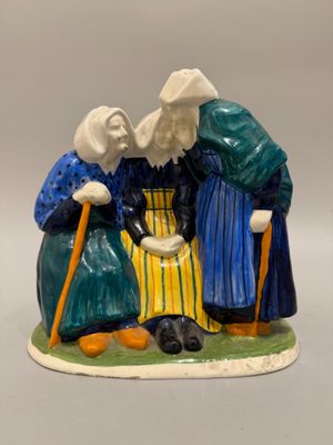 deux figurines représentant des personnes âgées, munies de cannes et coiffées de chapeaux, posées sur une surface blanche