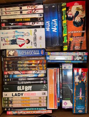 un grand nombre de dvd dans une boîte posée sur le sol