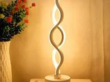 une lampe posée sur une table à côté d'un vase de fleurs