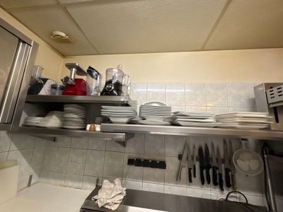 une cuisine où le plan de travail est encombré de vaisselle et d'ustensiles