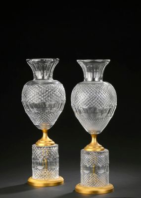 pair of cut glass vases on pedestals on a black background