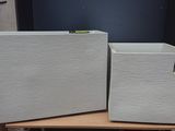 two white boxes sitting on top of a wooden table