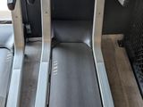 two tread machines are sitting on a wooden floor in a room