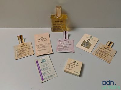 un flacon de parfum posé sur une table à côté de quelques cartes de visite