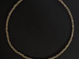 a gold necklace on a black background