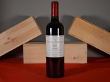 a bottle of wine sitting on a table next to two wooden boxes