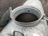 a metal pot sitting on top of a metal pipe