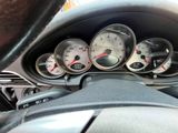 a close up of a car dashboard with gauges and a steering wheel