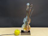 a sculpture of a violin and an apple on a table