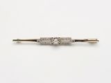 une broche antique en forme de barre sertie de diamants, sur fond blanc
