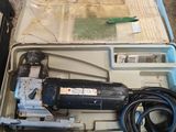un outil dans un étui posé sur le sol