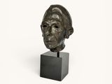 sculpture of a man ' s head on a black stand