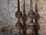 three vases sitting on a table in front of a brick wall