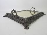 an ornate metal tray with a mirror on top of it