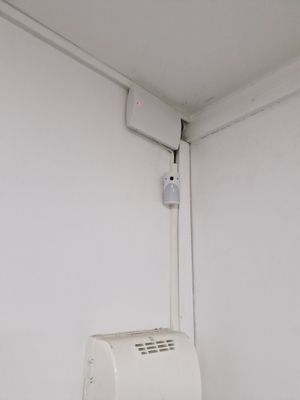 a white air conditioner on the wall in the corner of a room